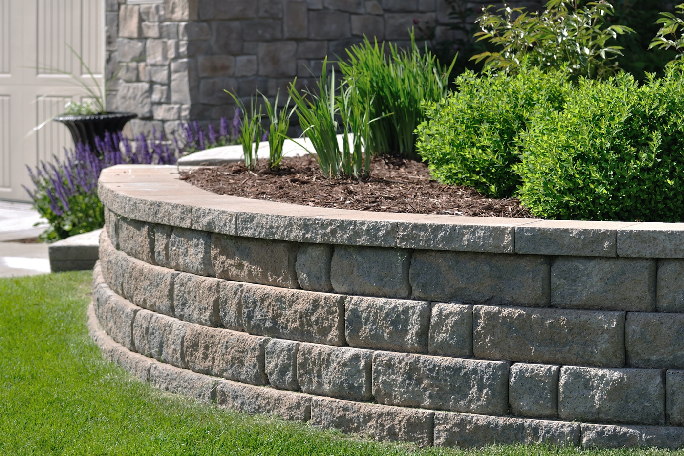 Natural stone retaining wall along a garden bed